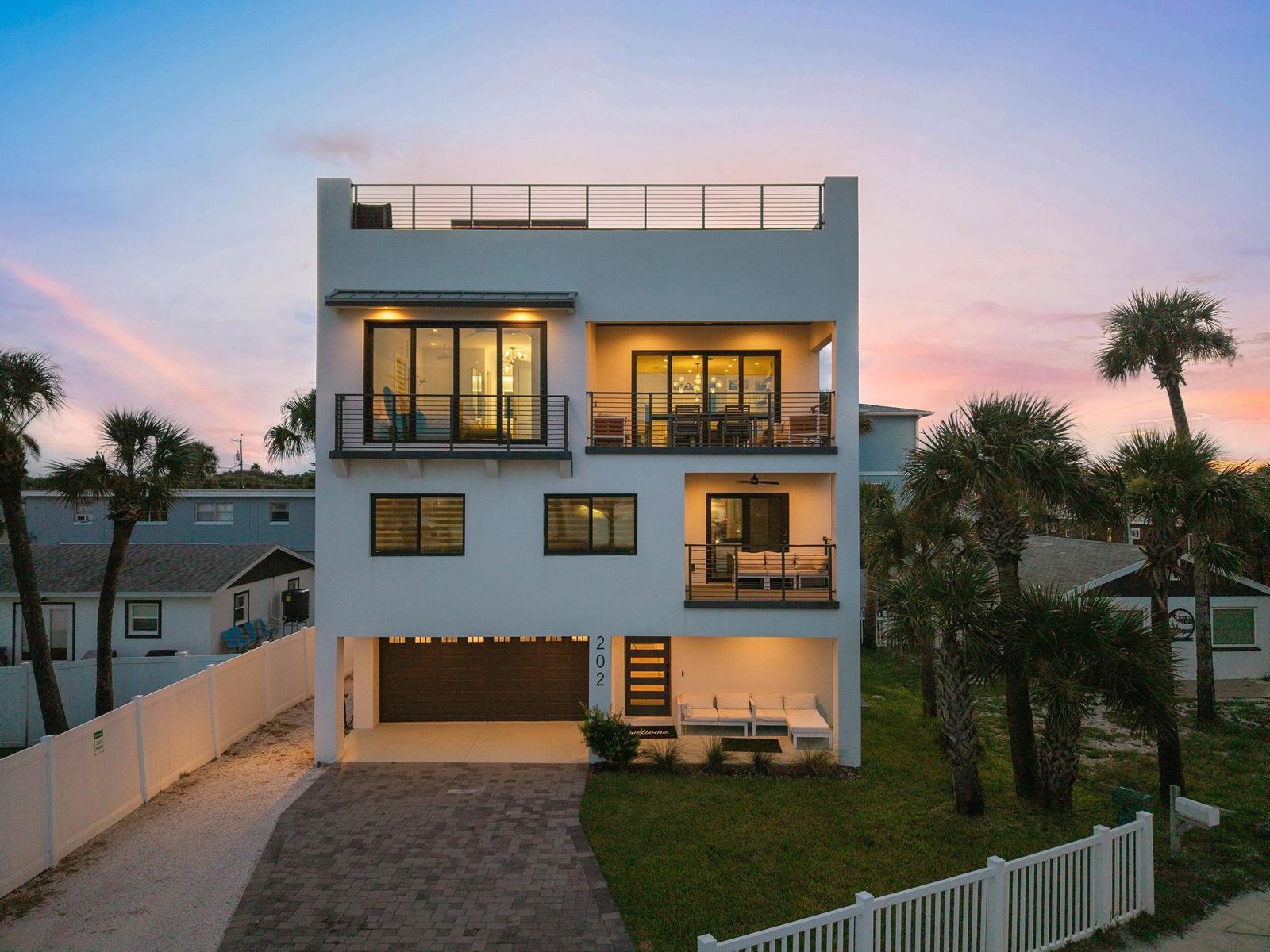 Front of the three-story home at twilight with lights on