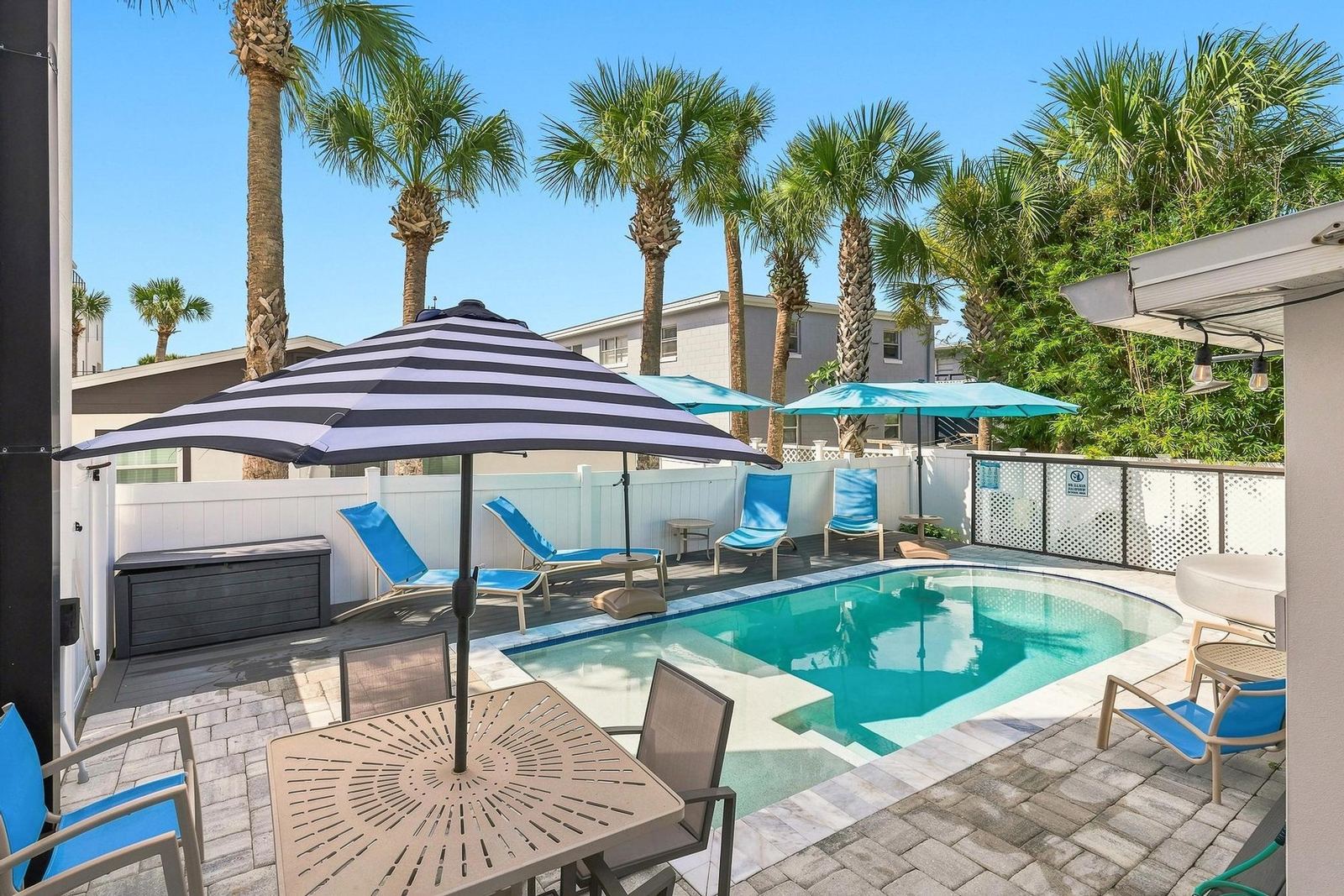 Pool deck with blue loungers and umbrellas