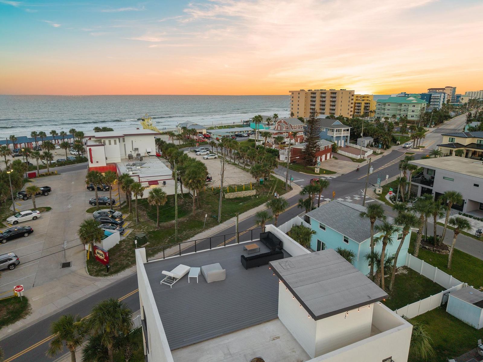 Aerial view of the rooftop at sunset with the ocean behind
