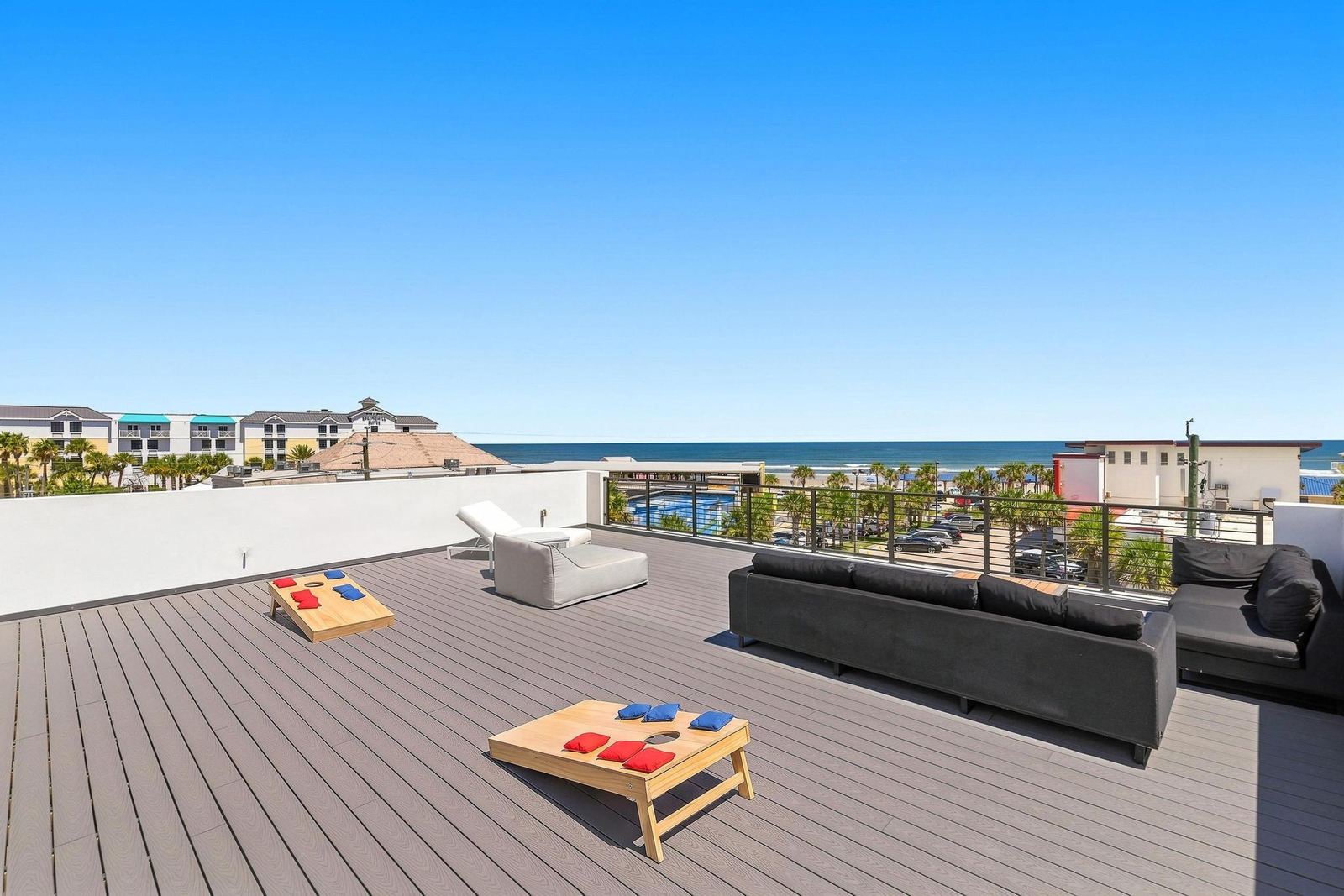Rooftop deck with cornhole boards, sofas and ocean view